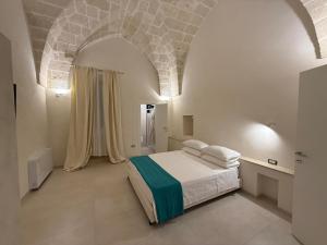 Un dormitorio blanco con una cama y un techo abovedado. en Palazzo Mancini, en Avetrana