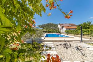 a villa with a swimming pool in a garden at Villa Zorka in Staševica