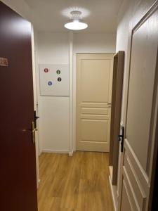 un couloir avec une porte et une chambre revêtue de parquet. dans l'établissement Résidence Les Hauts de Valmeinier 1900, à Valmeinier 12 autres photos