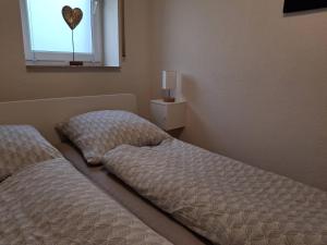 two beds in a room with a heart on the window at Nelke63 in Nordhorn