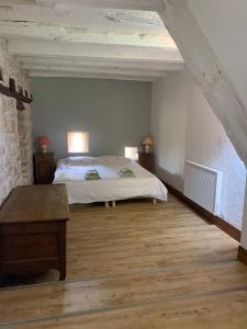a bedroom with a bed and two night stands and a table at Demeure avec piscine et tennis in Saint-Sozy