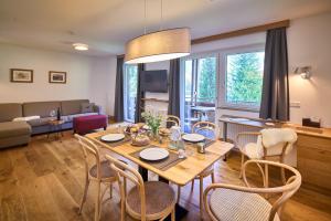 a dining room and living room with a table and chairs at Apartments Hohenberger Mallnitz - Bahnhofsshuttle bei An- und Abreise inklusive in Mallnitz