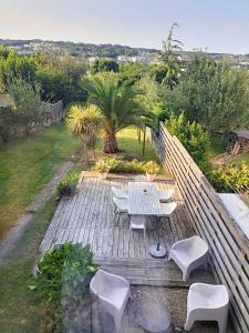 a patio with a table and chairs on a deck at Maison en ville au calme dans le Finistère in Landerneau
