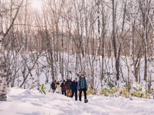 a group of people walking through the snow at Raicho Onsen Inn in Matsumoto