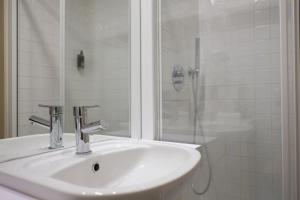 a bathroom with a sink, mirror, and bath tub at Sao Domingos by Oporto Tourist Apartments in Porto