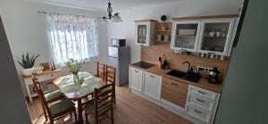 a kitchen with a table and a dining room at Szőlő Apartman in Villány
