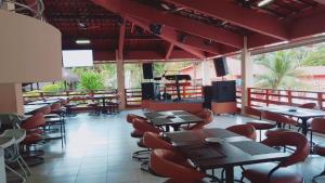 a restaurant with tables and chairs and televisions at Hot Springs Piscinas 24horas - Central de Reservas in Caldas Novas