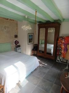 une chambre avec un lit blanc et un miroir dans l'établissement maison belle au bois dormant, à Rigny-Ussé