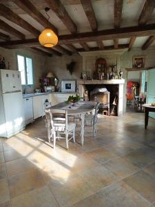 une cuisine avec une table et des chaises ainsi qu'une cheminée dans l'établissement maison belle au bois dormant, à Rigny-Ussé