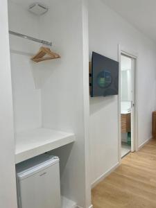 a white room with a tv on a wall at Elis rooms & suite in Olbia +24 photos