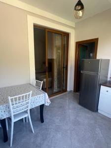 a kitchen with a table and a refrigerator at Leone Guesthouses in Borsh