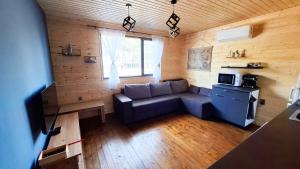 a living room with a couch in a wooden room at Еко Къщи Градина in Sozopol