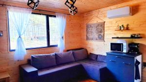 a living room with a couch and a window at Еко Къщи Градина in Sozopol