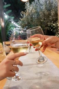 two people holding glasses of wine on a table at Villa Green Garden in Sarandë