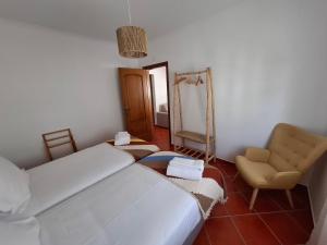 ポルト・コーヴォにあるCasa Areia - Porto Covoのベッドルーム1室(ベッド1台、椅子、鏡付)
