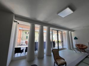 a room with columns and a chair and a window at Terra Buona Rooms in Traona
