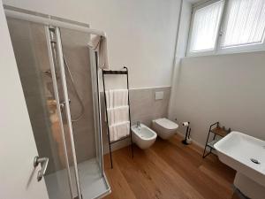 a bathroom with a shower and a toilet and a sink at Terra Buona Rooms in Traona