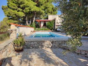 a swimming pool in a yard with a stone wall at Vacation house Milka in Milna