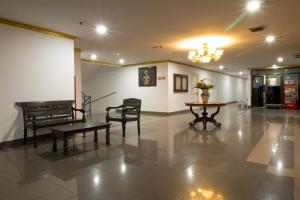 a lobby with a table and chairs and a piano at Sejahtera Apartment in Jogja 3bedrooms in Kejayan