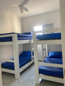 2 Etagenbetten in einem Zimmer mit blauer Bettwäsche in der Unterkunft Apto da Sol - 200m da Praia, Estacionamento e Wi-Fi in Praia Grande