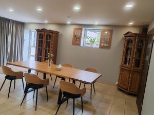 a dining room with a wooden table and chairs at Biały Zakątek in Trzebnica