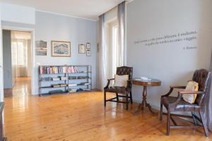 a room with two chairs and a table and a book shelf at Victoria Palace in Salò
