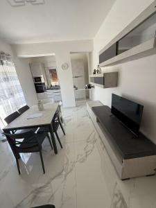 a kitchen and dining room with a table and a television at Sky Line Brolo in Brolo