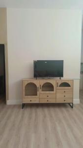 a wooden entertainment center with a flat screen tv on it at المنزل الآمن in Medina