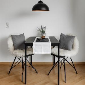 Una mesa de comedor negra con dos sillas y una lámpara negra. en Seeblick, en Daisendorf