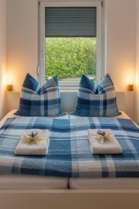 1 cama azul y blanca con almohadas azules y blancas en Seeblick, en Daisendorf