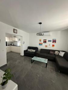 a living room with a black couch and a table at Apartment Oblak in Vrsi