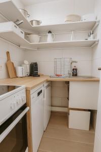 una cocina con armarios blancos y electrodomésticos blancos en Seeblick, en Daisendorf 2 fotos más