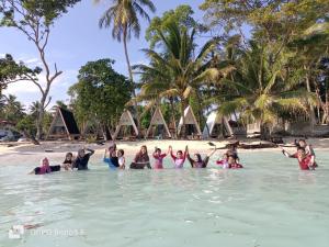 a group of people in the water at a beach at Krui Ocean Cottage BV in Krui