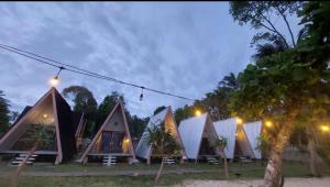 a group of tents in a field at night at Krui Ocean Cottage BV in Krui