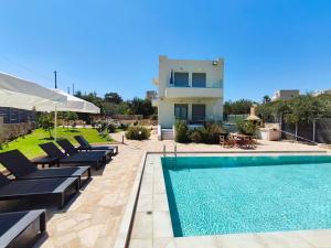 a villa with a swimming pool and a house at Horizon Villa Almyrida in Almirida