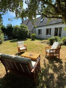 a group of chairs and a table in a yard at Maison trois chambres en impasse in Saint-Martin-des-Champs