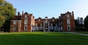 a large red brick building with a large grass yard at Wherstead Rd House By Homestyles Hosts Short Lets & Serviced Accommodation Suffolk With Free Parking in Ipswich