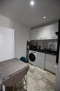 a kitchen with a table and a washing machine at Le Petit Cocon in Château-Chinon +12 photos