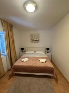 a bedroom with a bed with two towels on it at Apartment Oblak in Vrsi