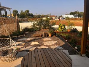 a garden with a wooden table and a patio at הבית של טלי in Kfar Yehezkel +6 photos