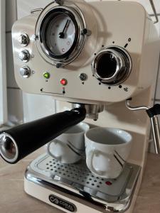 a coffee machine with two cups on aucer at Apartman Tabaković in Bileća