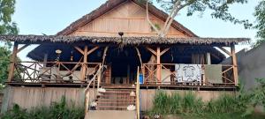 a house with a thatched roof and a porch at La Maison de Morgana in Ambaro