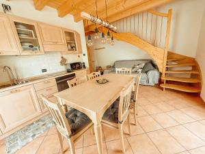 a kitchen with a table and chairs and a staircase at Alloggio Stella Alpina in Sondalo