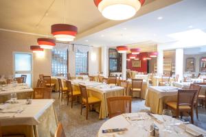 a dining room with tables and chairs and lights at Hotel Ferrari in Salsomaggiore Terme