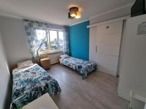 a bedroom with two beds and a window at Pokoje Złota Rybka in Stegna +12 photos