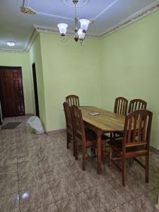 Un comedor con mesa y sillas de madera. en Les suites de Biteng, en Yaoundé