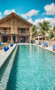 a pool at a resort with chairs and a building at Villa Beleza Prea Beachfront private room in Prea