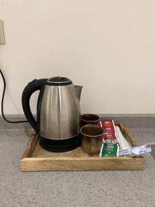 a tea kettle on a wooden tray with a cup at شقة بصالة جلوس وغرفه نوم in Al Kharj +4 photos