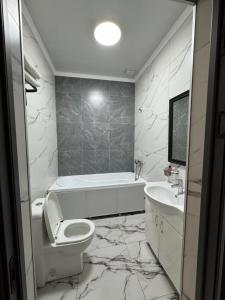 a bathroom with a white toilet and a sink at Imereti in Almaty
