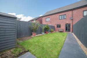 a backyard with a fence and a brick building at Town house Anfield stadium in Liverpool